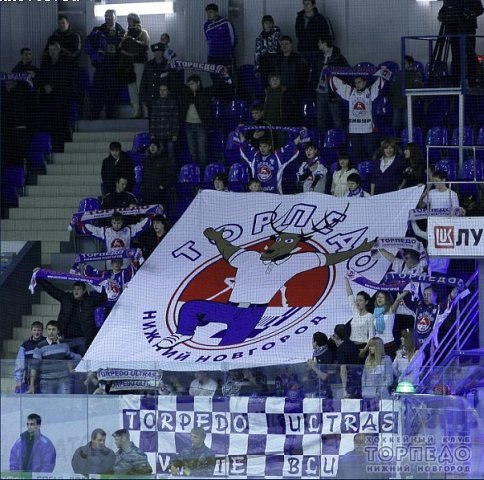 A generalized representative of The Peoples of Nizhny Novgorod — a reindeer-person in thick blue trousers and a neat shirt. A Torpedo Ultras poster