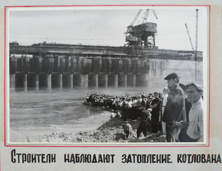 Construction workers watch the flooding of the excavation pit
