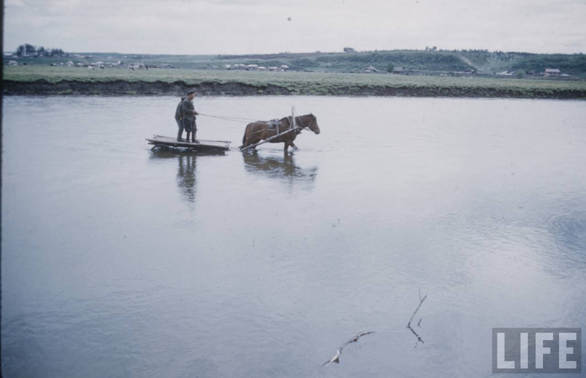 Crossing the river by raft with a horse