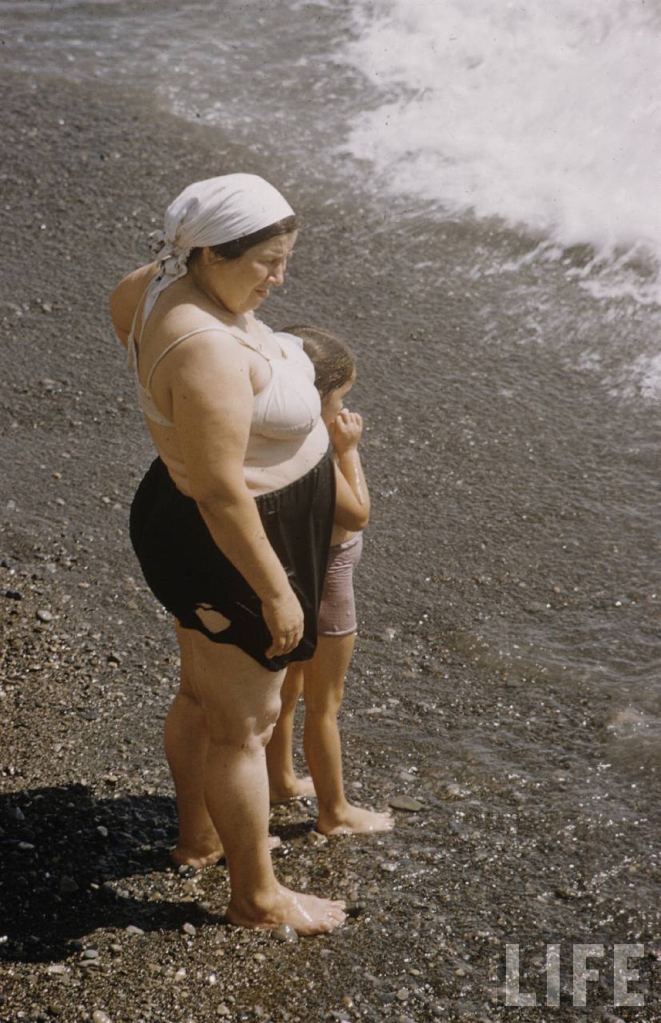 Pebble beach, woman with a child, LIFE