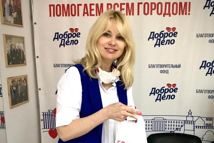 Анна Татаринцева в приёмной фонда «Доброе дело» под баннером акции «Помогаем всем городом»