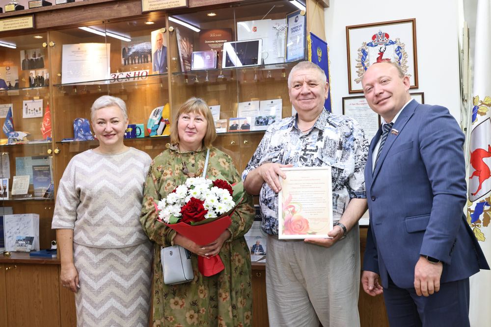 Максим Ребров (справа) вручает благодарность на открытии выставки «Рука об руку» в Законодательном собрании Нижегородской области