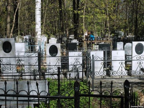 Мусульманский участок кладбища "Красная Этна" после атаки фундаменталистов, замазавших изображения покойных черной краской